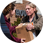 A person delivering a parcel to another person.